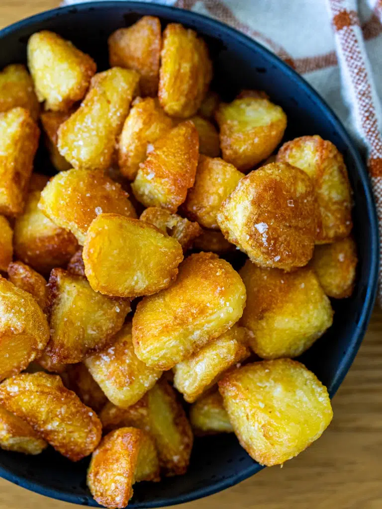 close-up of crispy golden roast potatoes in a bowl