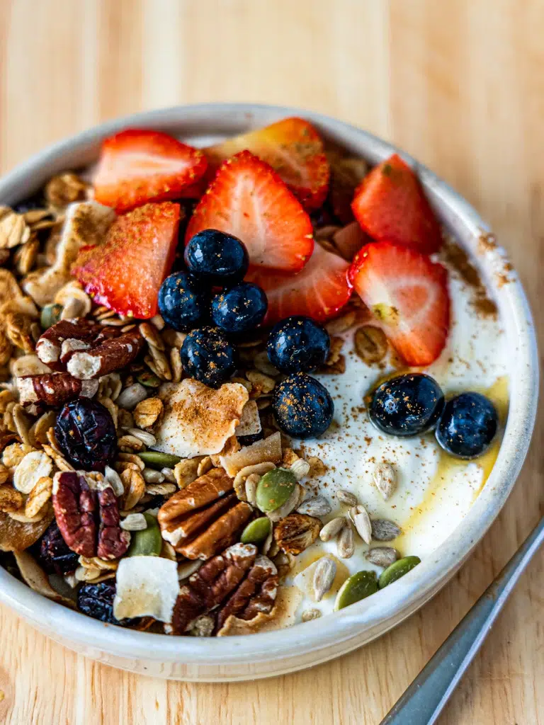 Close-up view of crunchy granola with a mix of nuts and berries.