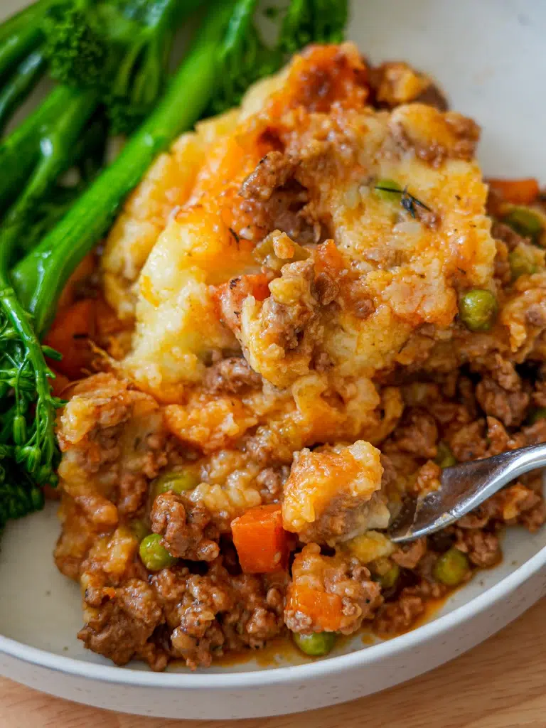 Bowl of Shepherd's Pie with a garnish of fresh greens.