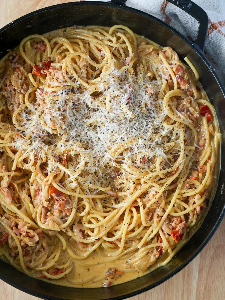 Overhead shot of pasta in a black pan, ready to be served.