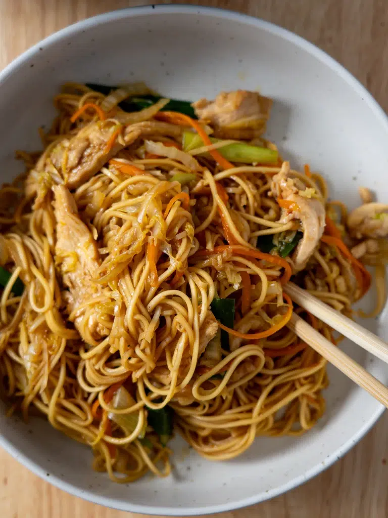 Overhead shot of plated Chicken Lo Mein with chopsticks.