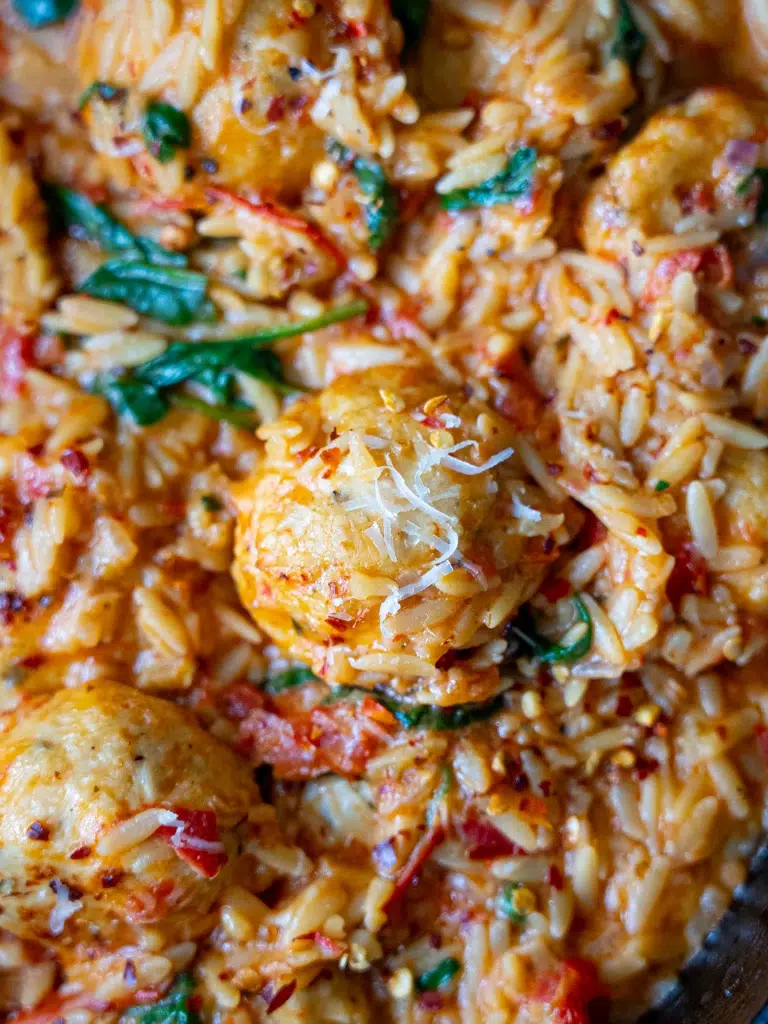 Close-up of a Marry Me Chicken Meatball coated in a creamy, golden sauce.