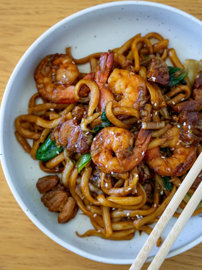 Overhead shot of Malaysian-inspired Hokkien Mee served on a plate with chopsticks.