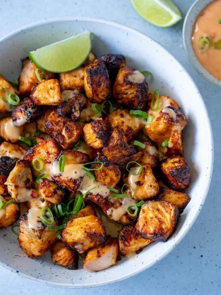 Close-up of crispy Bang Bang salmon pieces in a white bowl