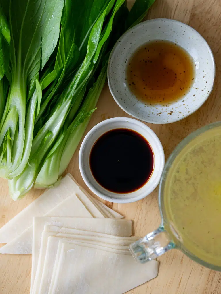 Overhead shot of fresh aromatics and seasonings prepared for wonton soup broth.