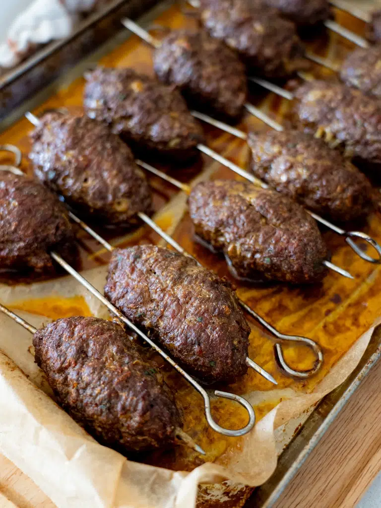 Juicy lamb kofta skewers cooked on the stovetop, arranged in a tray ready to serve.