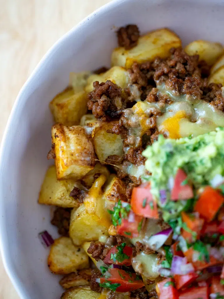 Top view close-up of golden roasted potato nacho bowl