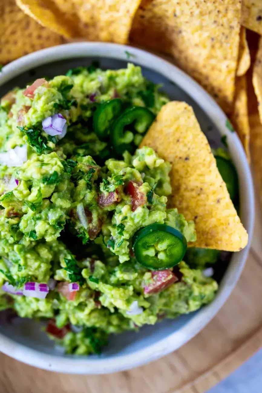 Close up of Guacamole with corn chips and jalapenos