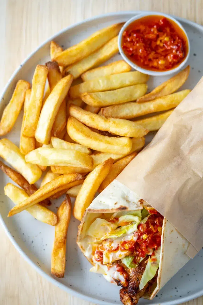 Portuguese-style chili chicken wrap with lettuce and sauce served with golden fries and chili dip
