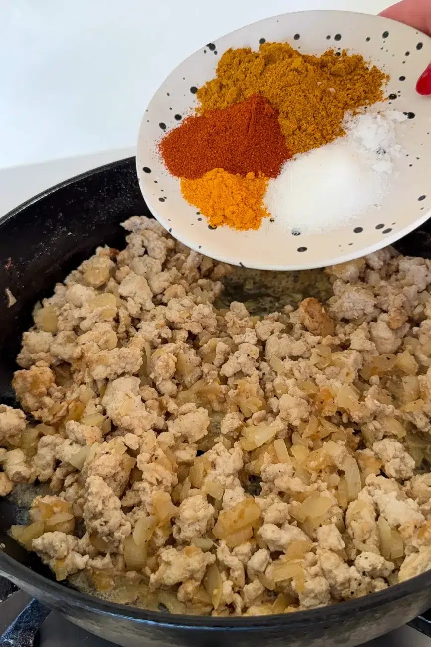 Cook chicken mince in pan with spices