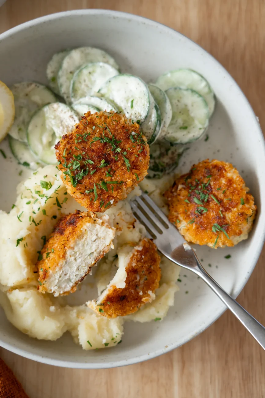 Plated rissoles, one cut in half to reveal juicy centre