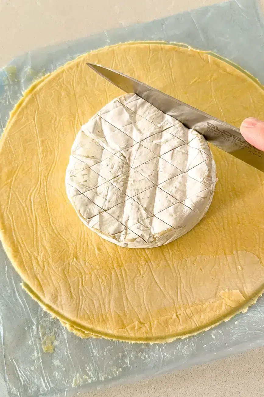 Brie placed on puff pastry circle scored with diamond cut