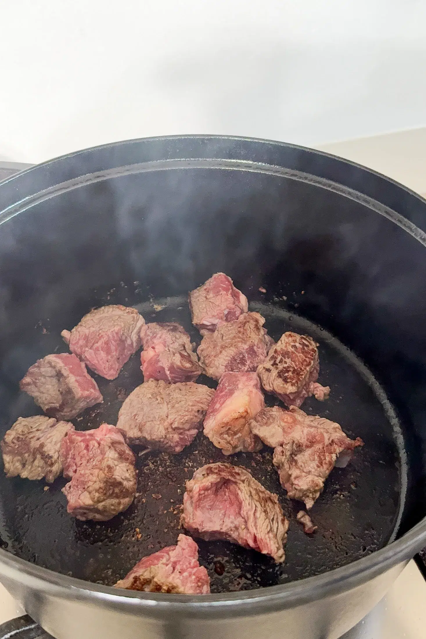 Browning beef chuck in batches in a deep pan