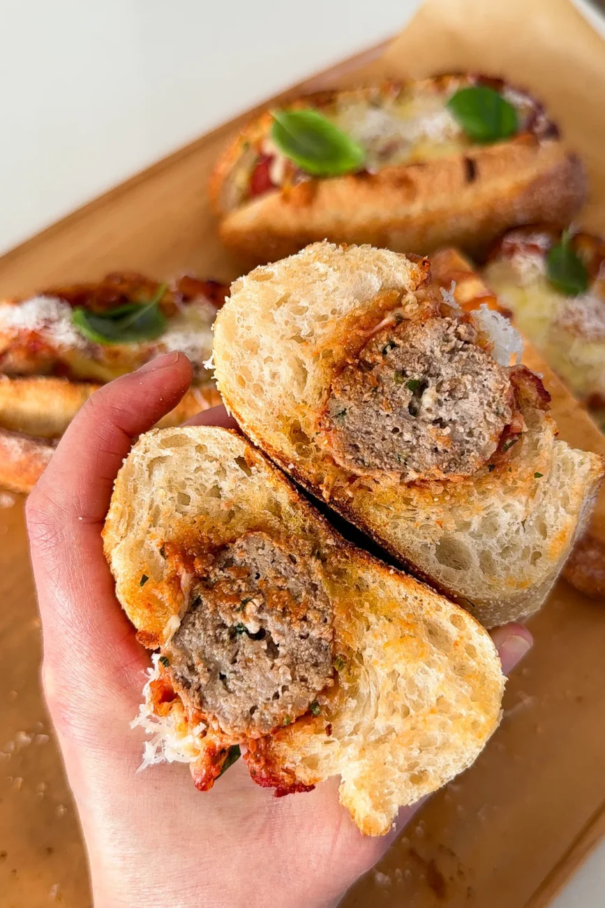 meatball sub cut in half crossways to reveal delicious tender meatball