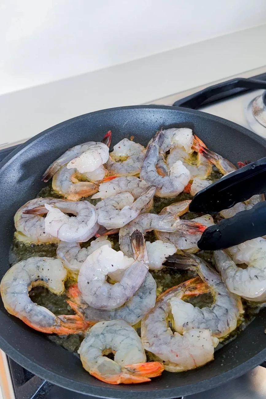 raw prawns seasoned and added to pan